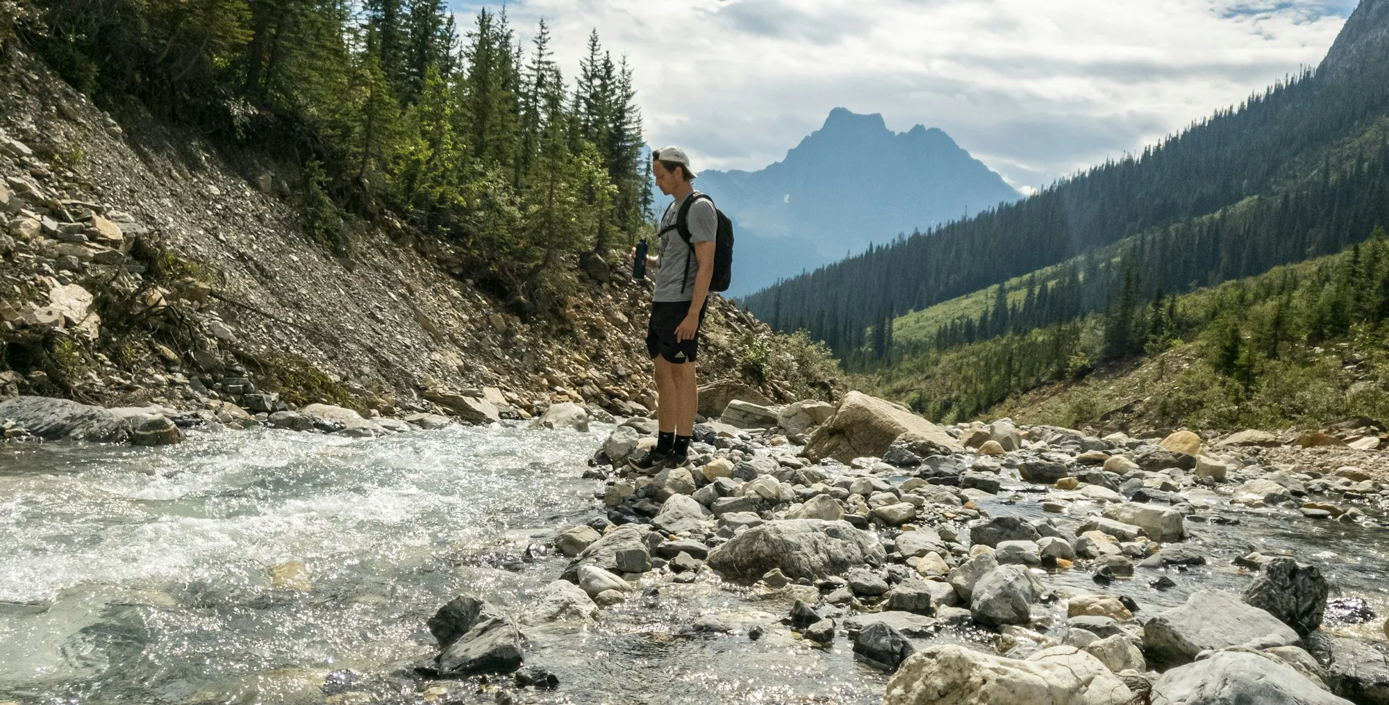 Hiker with a backpack beside a mountain river